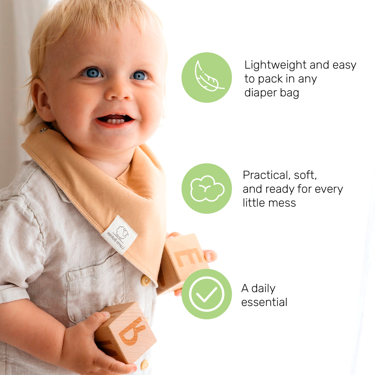 Smiling baby wearing a tan Lamb Babies Bandana Bib