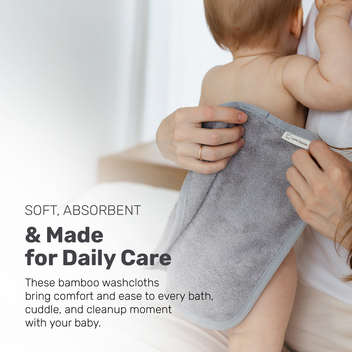 Parent drying a baby with a gray Lamb Babies washcloth