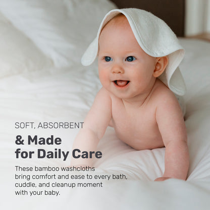 Smiling baby with a white Lamb Babies washcloth on their head